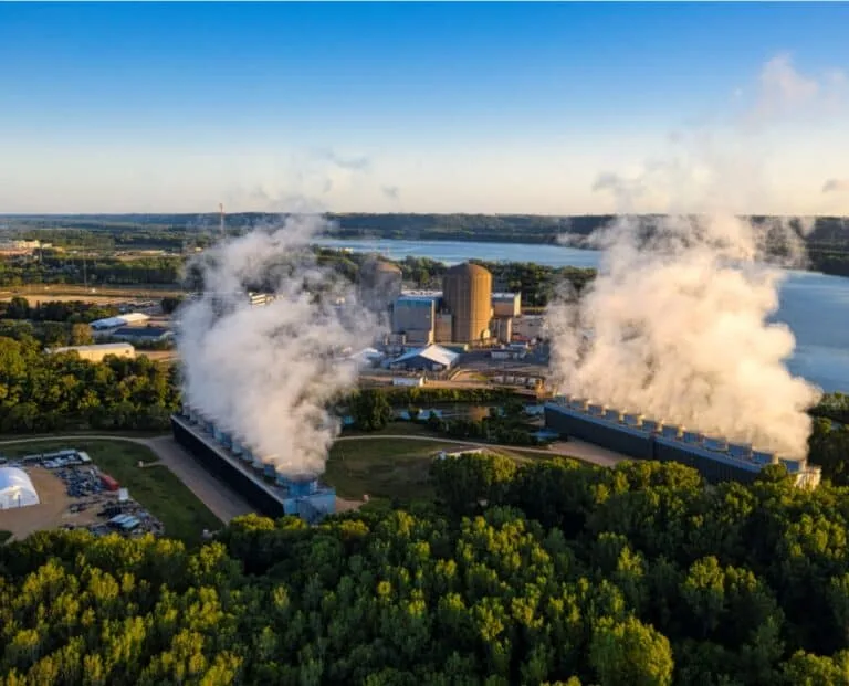 Aerial view of an industrial plant with cooling plumes beside a river, QEQI® RO potabilisation plant scale case study Italy