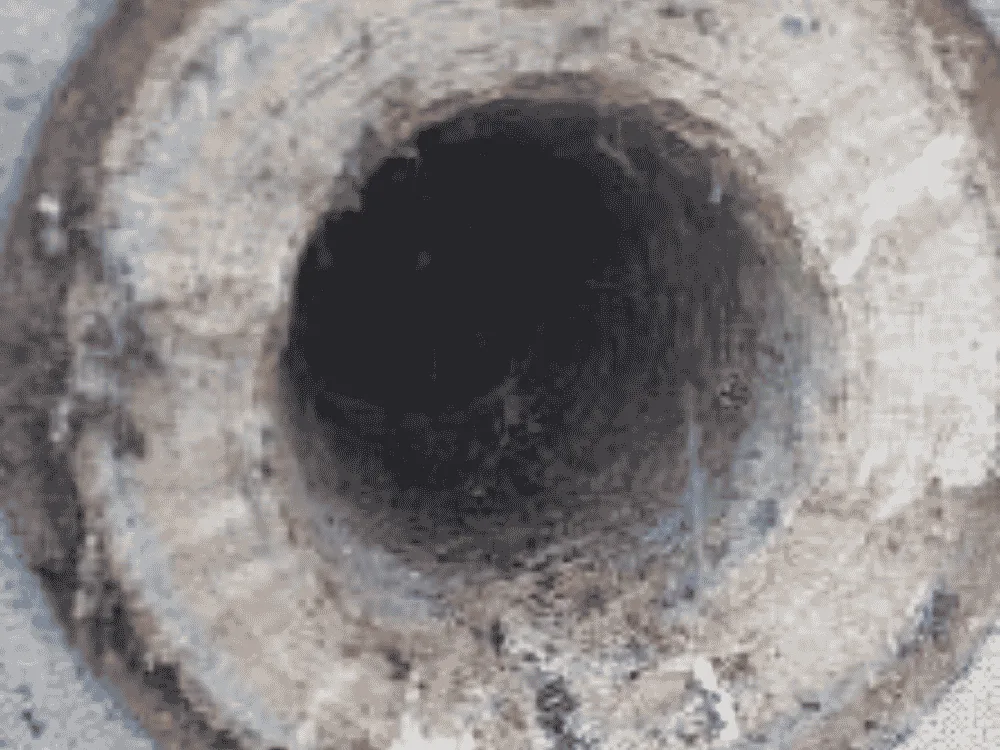 Luton WWTP centrate line before QEQI® — hard struvite scale on pipework